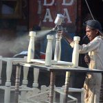 A young painter busy in painting iron frame at his workplace