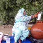 Woman busy in selling traditional summer drink (Lassi) at her roadside setup
