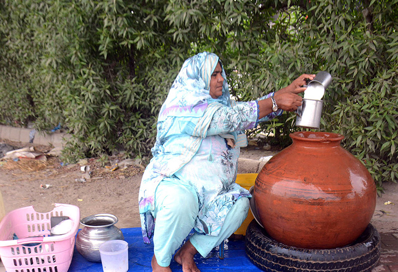Woman busy in selling traditional summer drink (Lassi) at her roadside setup