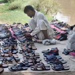 Vendor displaying old footwear to attract customers at Bank of Canal
