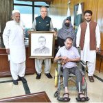 President Dr Arif Alvi receiving his portrait made by Mr Umer Jarral, an artist with cerebral palsy, at Aiwan-e-Sadr