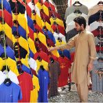 A youngster purchasing a shirt at G-9 Markaz
