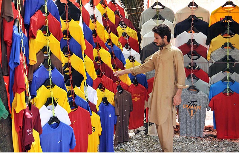 A youngster purchasing a shirt at G-9 Markaz