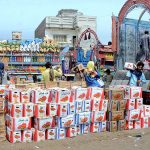 Labourers are busy unloading tomatoes on the delivery trucks at the vegetable Market