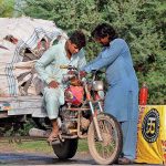 A tricycle loader holder purchasing fuel from an illegal petrol selling point along the roadside setup and needs the attention of concerned authorities