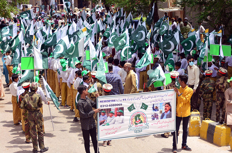 A woman busy in selection and purchasing Pakistan Independence Day related stuff from stall in the city