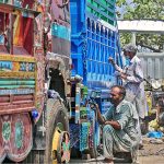 Painters busy in painting on the body of a truck at Pirwadhai