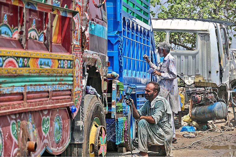 Painters busy in painting on the body of a truck at Pirwadhai