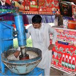 A vendor is busy in preparing traditional summer drink (Sardai) for customers at his roadside setup