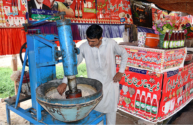 A vendor is busy in preparing traditional summer drink (Sardai) for customers at his roadside setup