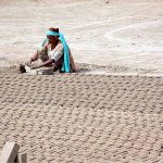 A woman labourer busy in preparing bricks at local bricks kiln