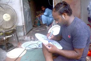 A skilled worker reparing parts of traditional drum (Dhool) at his workplace