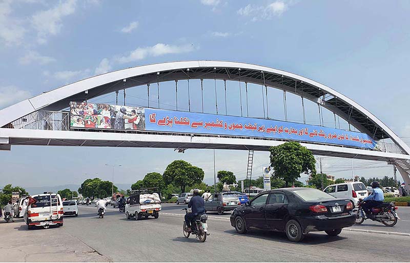 Workers busy in paint the overhead pedestrian bridge at Islamabad Expressway
