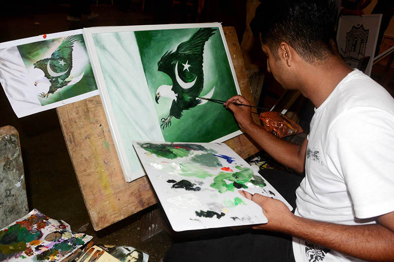 An artist busy in giving final touch on the painting for independence day at NCA