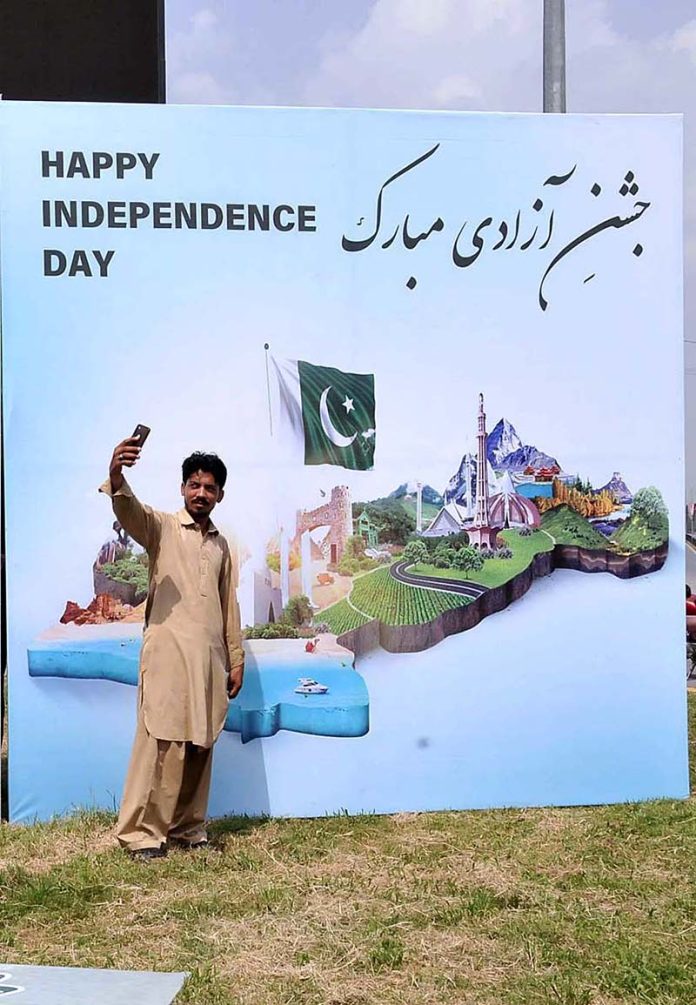 A man taking selfie with Pakistan Map model during Independence Day in the Federal Capital