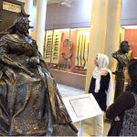 The students who visit the Lahore Museum are exchanging information and enhancing their own memories by looking at the statue of Queen Victoria of Great Britain