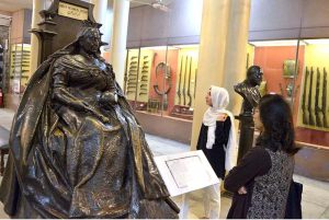 The students who visit the Lahore Museum are exchanging information and enhancing their own memories by looking at the statue of Queen Victoria of Great Britain