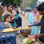 Women purchasing corn from vendor at Almanzar picnic point Jamshoro