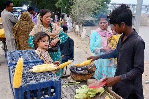 Women purchasing corn from vendor at Almanzar picnic point Jamshoro