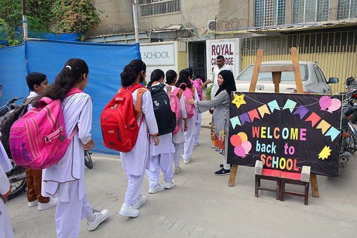Students arrive to attend school on the opening day after two month Summer Vacation at Latifabad