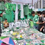 Youngsters busy in selecting and purchasing National flag and related stuff from vendor in connection with Pakistan Independence Day celebrations