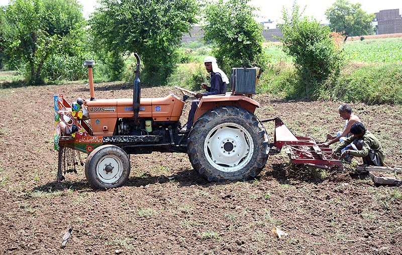 Farmers busy in ploughing his field with the help of tractor for next crop