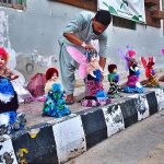 A vendor displaying the colorful dolls to attract the customers at roadside