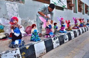 A vendor displaying the colorful dolls to attract the customers at roadside