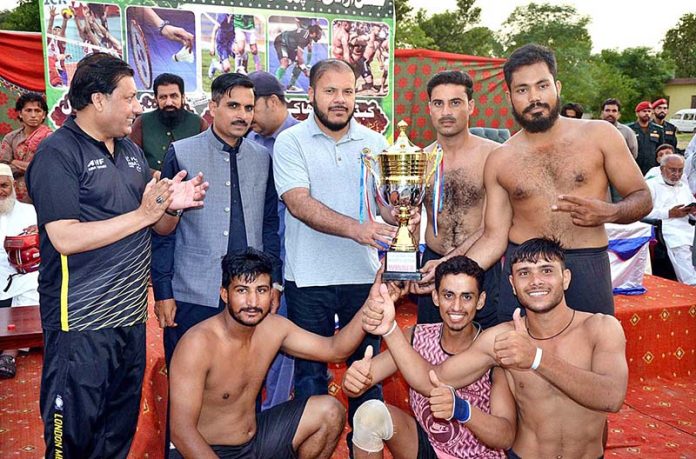 ADC Finance Waqar Akbar Cheema giving the trophy to the team of Hazro who secured the 1st position in the Kabaddi Match held on the occasion of 77th Independence Day celebration