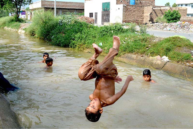 Youngster jumping in the canal to take bath during the humid day in the city