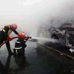 RESCUE 1122 officials extinguishing fire on bus after incidence while eighteen people were killed and fifteen others injured when a passenger bus caught fire after being smashed into a pick-up carrying diesel drums at Motorway near Pindi Bhattian
