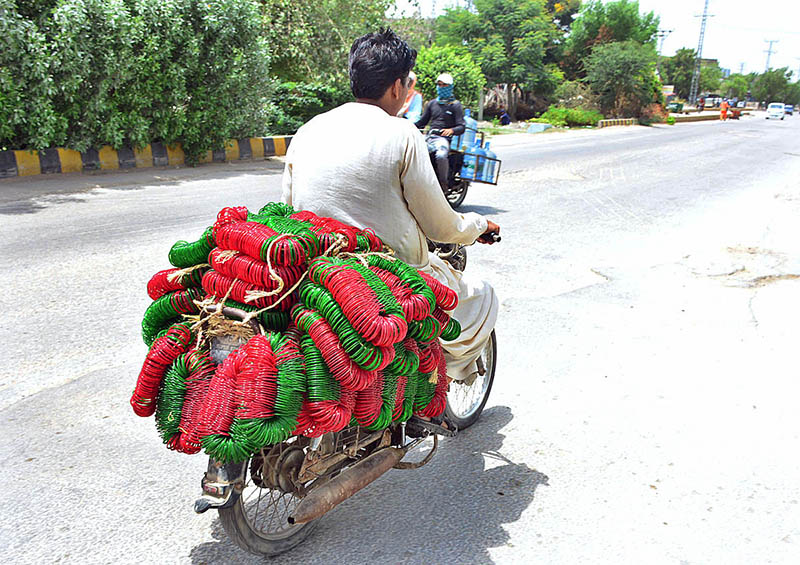 A motorcyclist on the way loaded with bangles delivery to bangle market