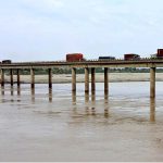 A view of heavy vehicles passing through on the Mehran Bridge over the River Indus at bypass