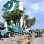 Vendor displaying national flags to attract the customer’s in preparation of upcoming Independence Day celebration of Pakistan