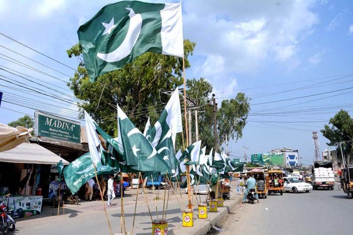 Vendor displaying national flags to attract the customer’s in preparation of upcoming Independence Day celebration of Pakistan Vendor displaying national flags to attract the customer’s in preparation of upcoming Independence Day celebration of Pakistan