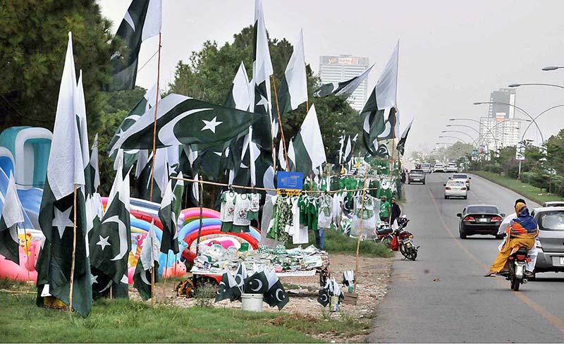 Youngsters busy in selecting and purchasing National flag and related stuff from vendor in connection with Pakistan Independence Day celebrations
