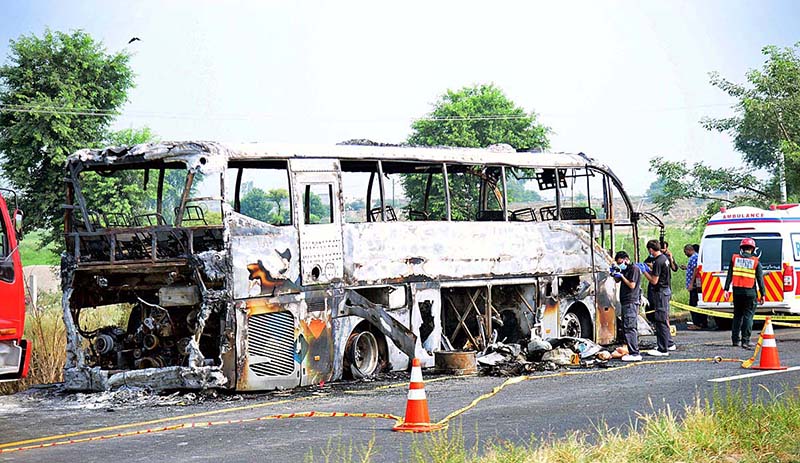 RESCUE 1122 officials extinguishing fire on bus after incidence while eighteen people were killed and fifteen others injured when a passenger bus caught fire after being smashed into a pick-up carrying diesel drums at Motorway near Pindi Bhattian