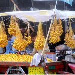 A vendor displaying and selling fresh dates at his roadside setup