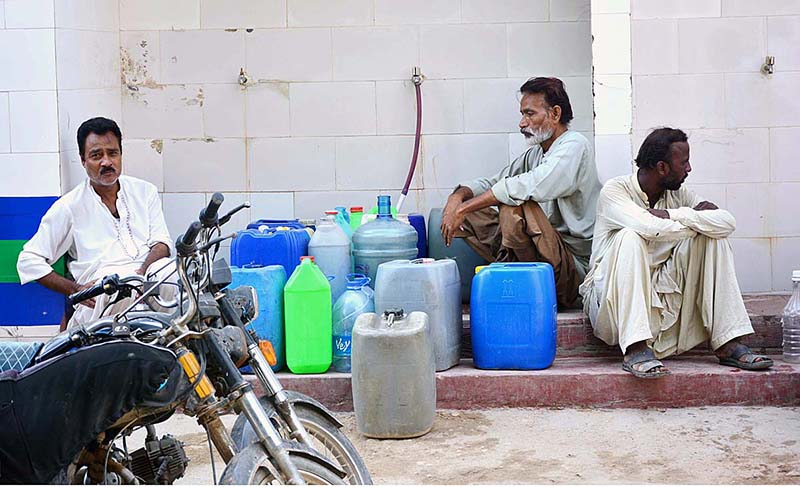 People filling their pots with clean drinking water from water filtration plant at Latifabad