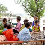 Children sitting on traditional bad (charpai) at kacha area near Indus river