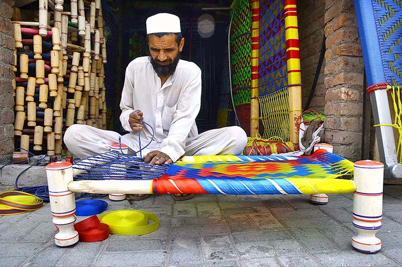 A man is busy in making traditional Charpai in his work place at Dabgari area