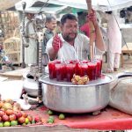 Vendor selling pomegranate juice at his roadside setup.