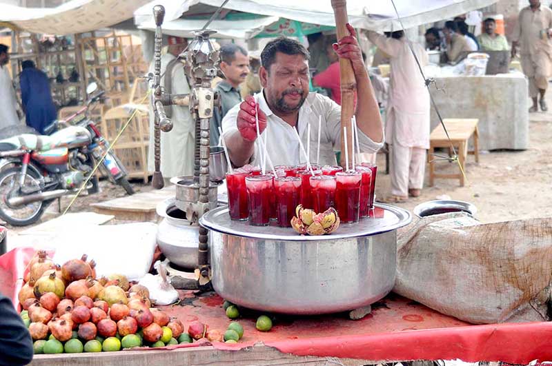 Vendor selling pomegranate juice at his roadside setup