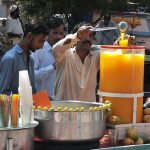 A vendor selling summer drink to customers in Federal Capital