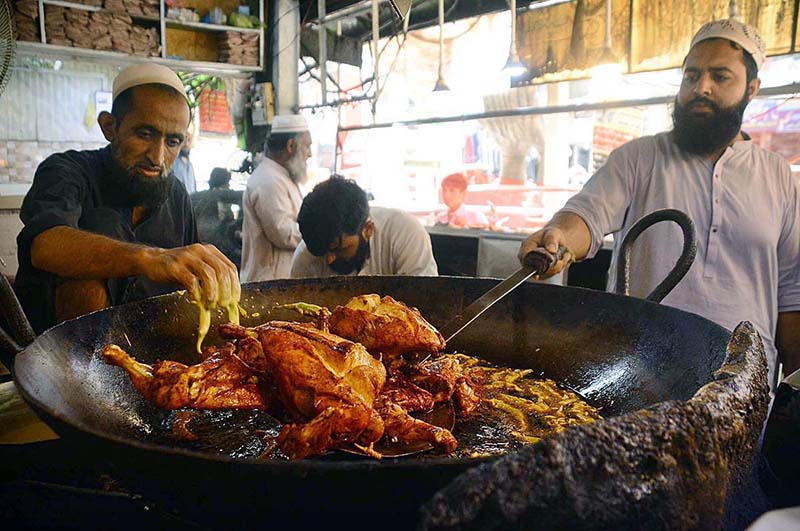 Vendors frying chickens for customers at Qissa Khawani Bazaar