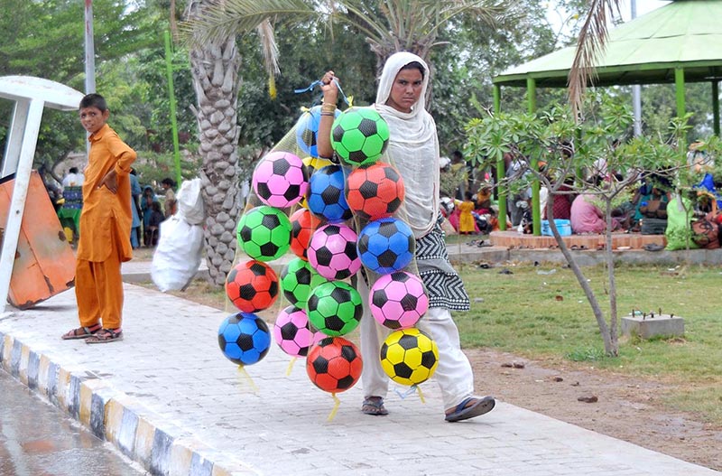 A woman selling football while shuttling in the park