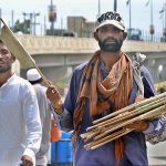 A vendor selling hand fans while shuttling on the road