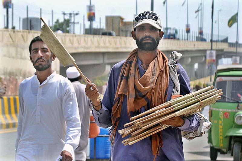 A vendor selling hand fans while shuttling on the road