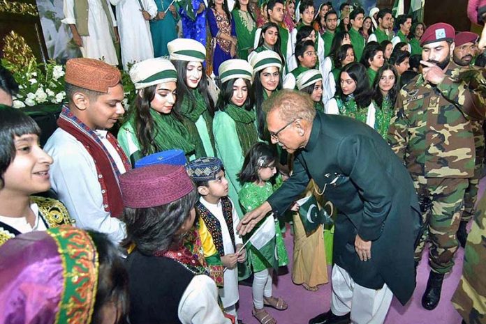 President Dr. Arif Alvi shaking hands and exchanging Independence Day greetings with children at the official flag hoisting ceremony on the 77th Independence Day of Pakistan