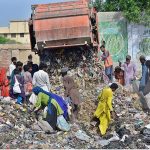 Gypsy people searching valuables items in the garbage at Latifabad
